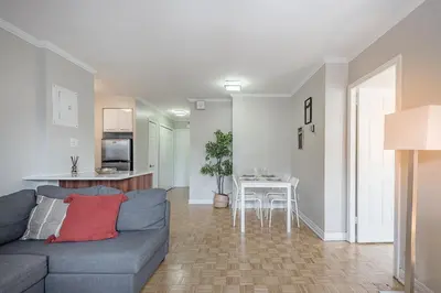 a living room with a blue couch and a kitchen at Outstanding 1BR in Heart of Downtown Montreal in Montréal