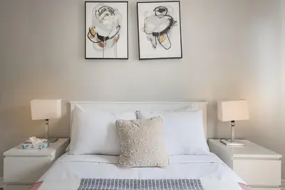 a bedroom with a bed with three pictures on the wall at Outstanding 1BR in Heart of Downtown Montreal in Montréal