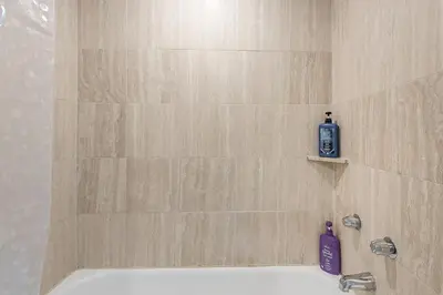 a shower with a bottle of soap on a tile wall at Outstanding 1BR in Heart of Downtown Montreal in Montréal