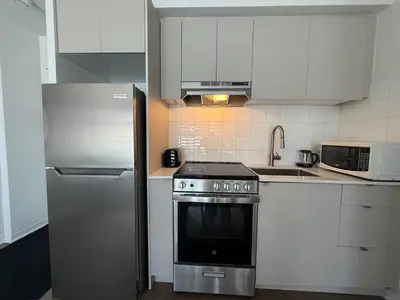 a kitchen with a stainless steel stove and refrigerator at McGill Les Petits Studios, Downtown & Nightlife in Montréal