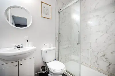 a bathroom with a toilet and a sink and a shower at Charmant 2BD in Montréal