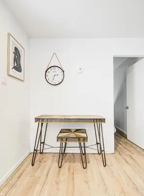 a table in a room with a clock on a wall at Charmant 2BD in Montréal