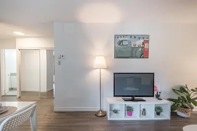 a living room with a television on a white table at Spacious and Cozy 1BR - Near Old Port in Montréal