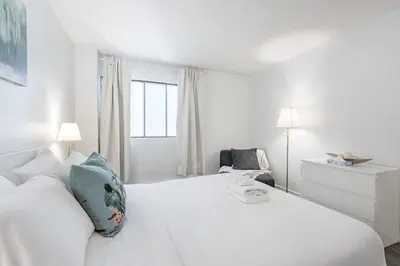 a white bedroom with a white bed and a window at Spacious and Cozy 1BR - Near Old Port in Montréal
