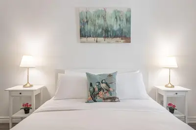 a bedroom with a white bed with two lamps at Spacious and Cozy 1BR - Near Old Port in Montréal
