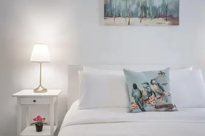 a white bed with a pillow with birds on it at Spacious and Cozy 1BR - Near Old Port in Montréal