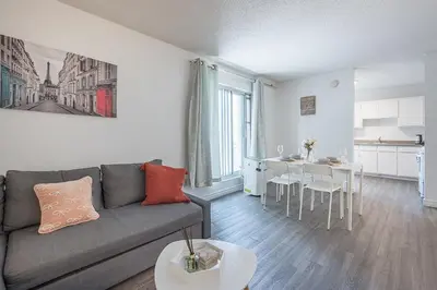 a living room with a gray couch and a kitchen at Spacious and Cozy 1BR - Near Old Port in Montréal