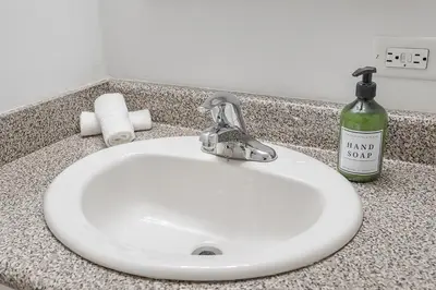 a white sink with a bottle of hand soap on a counter at Spacious and Cozy 1BR - Near Old Port in Montréal