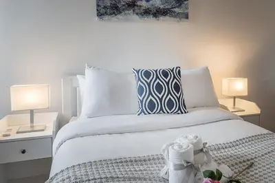 a bedroom with a white bed with two lamps at 1BR Downtown MTL - Walk to Old Port in Montréal