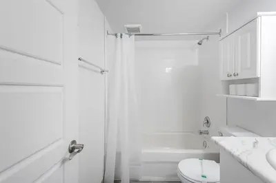 a white bathroom with a shower and a toilet at 1BR Downtown MTL - Walk to Old Port in Montréal