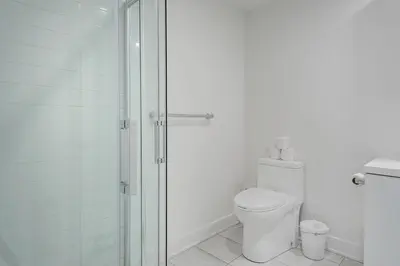 a white bathroom with a shower and a toilet at Downtown Montreal 1BR - Sleeps 4 in Montréal