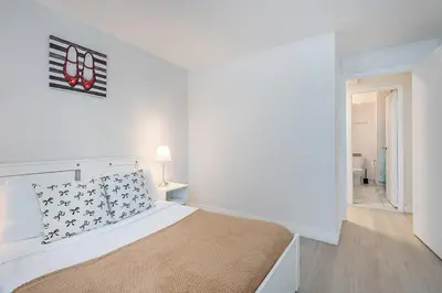 a white bedroom with a bed in a room at Modern 1BR - Central Location in Montréal