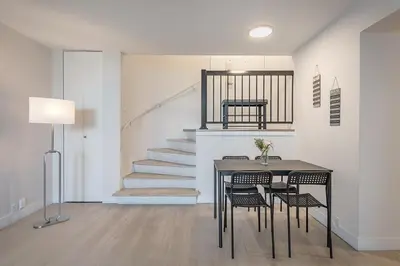 a dining room with a table and chairs and a staircase at Modern 1BR - Central Location in Montréal