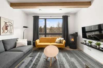 a living room with a couch and a tv at Magnifique Condo pour 4 à Orford in Magog-Orford