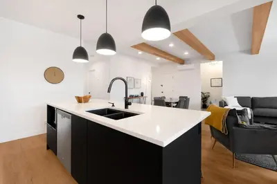 a kitchen with a sink and a living room at Magnifique Condo pour 4 à Orford in Magog-Orford
