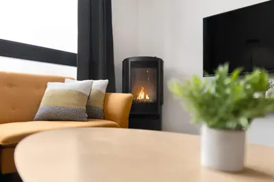 a fireplace in a living room with a couch and a table at Magnifique Condo pour 4 à Orford in Magog-Orford