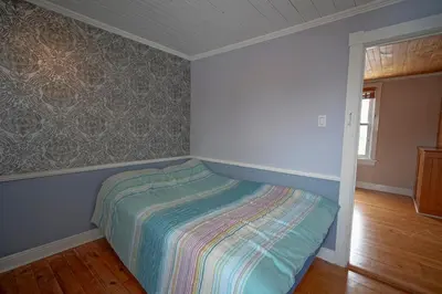 a small bedroom with a bed in the corner at Bashtina Inn and Spa in Saint-Césaire