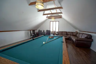 a living room with a pool table and a couch at Bashtina Inn and Spa in Saint-Césaire