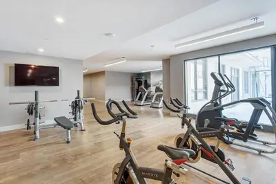 a gym with treadmills and exercise bikes in a room at Corporate Stays Equinoxe 3 Bedrooms in Laval