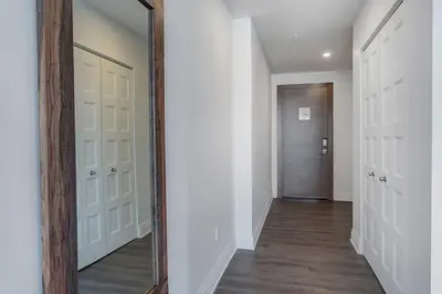 a hallway with a mirror and a door at Corporate Stays Equinoxe 3 Bedrooms in Laval