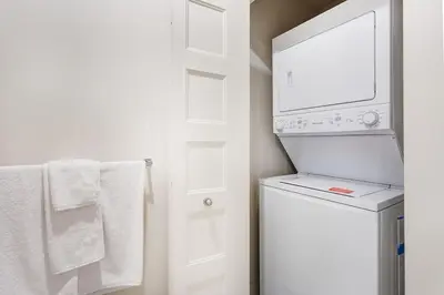 a white laundry room with a washer and dryer at Corporate Stays Equinoxe 3 Bedrooms in Laval