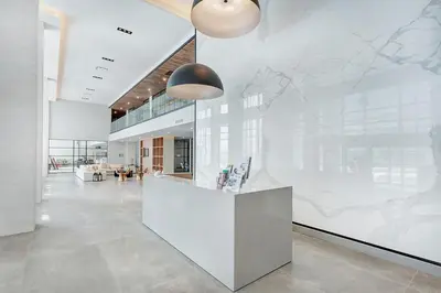 an office lobby with a large white wall with a mural at Corporate Stays Equinoxe 3 Bedrooms in Laval