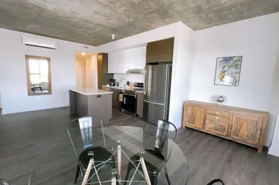 a kitchen with a glass table and a stainless steel refrigerator at Corporate Stays Monarc 2 Bedroom in Montréal