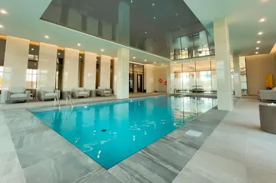 a large pool in a building with blue water at Corporate Stays Monarc 2 Bedroom in Montréal