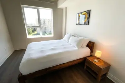 a bedroom with a large white bed with a window at Corporate Stays Monarc 2 Bedroom in Montréal