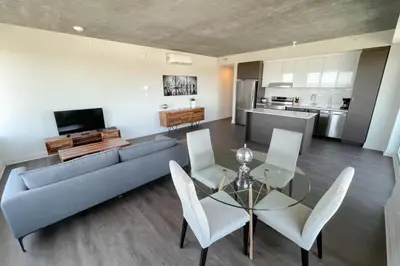 a living room with a couch and a table and chairs at Corporate Stays Monarc 2 Bedroom in Montréal