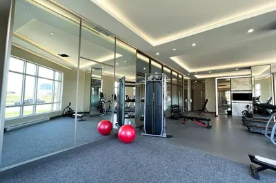 a gym with cardio equipment in a large room with mirrors at Corporate Stays Monarc Bedroom in Montréal