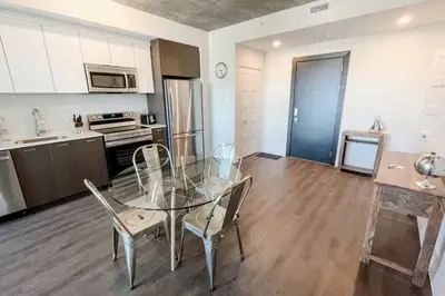 a kitchen and dining room with a glass table and chairs at Corporate Stays Monarc Bedroom in Montréal