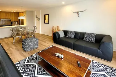 a living room with a black couch and a table at Corporate Stays Blum 1 Bedroom in Brossard