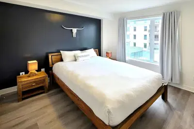 a bedroom with a large bed with a black wall at Corporate Stays Blum 1 Bedroom in Brossard