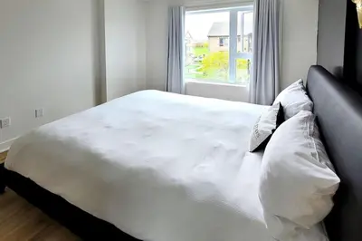 a white bed in a room with a window at Corporate Stays Blum 1 Bedroom in Brossard