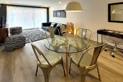 a living room with a glass table and chairs at Corporate Stays Blum 1 Bedroom in Brossard
