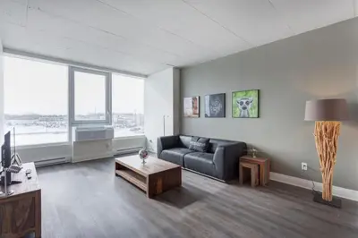 a living room with a couch and a coffee table at Corporate Stays Equinoxe 1 Bedroom in Laval