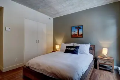 a bedroom with a large bed with two lamps at Corporate Stays Equinoxe 1 Bedroom in Laval