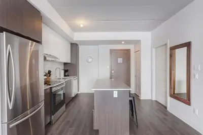 a kitchen with a stainless steel refrigerator and a counter at Corporate Stays Equinoxe 1 Bedroom in Laval
