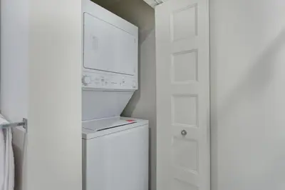 a white laundry room with a washer and dryer at Corporate Stays Equinoxe 1 Bedroom in Laval