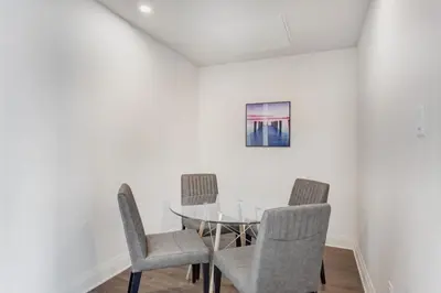 a dining room with a glass table and chairs at Corporate Stays Equinoxe 1 Bedroom in Laval
