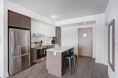 a kitchen with stainless steel appliances and a counter top at Corporate Stays Equinoxe 1 Bedroom in Laval