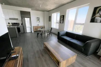 a living room with a black couch and a table at Corporate Stays Monarc 2 Bedrooms in Montréal