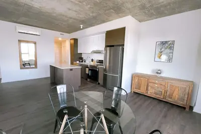 a kitchen with a glass table and a stainless steel refrigerator at Corporate Stays Monarc 2 Bedrooms in Montréal