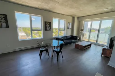 a living room with a table and chairs and a couch at Corporate Stays Monarc 2 Bedrooms in Montréal