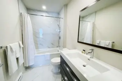 a bathroom with a sink and a toilet and a mirror at Corporate Stays Monarc 2 Bedrooms in Montréal