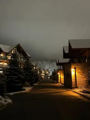 a street at night with a mountain in the background at Ski in out condo sur la montagne in Bromont