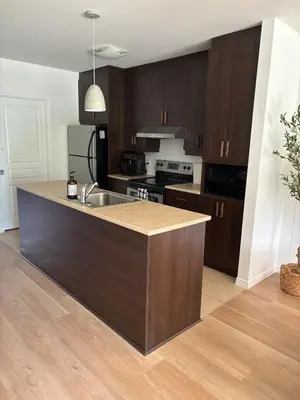 a kitchen with wooden cabinets and a counter top at Ski in out condo sur la montagne in Bromont