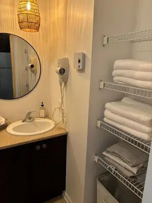 a bathroom with a sink and a mirror and towels at Ski in out condo sur la montagne in Bromont