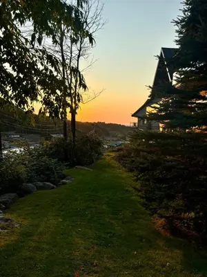 a path leading to a house with the sunset in the background at Ski in out condo sur la montagne in Bromont